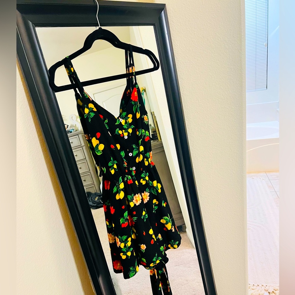 Romper, black with fruit, a tie in the back to cinch the waist.
